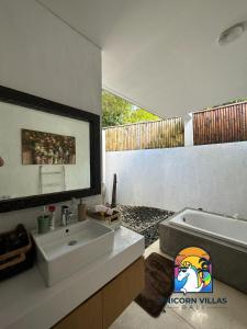 a bathroom with a sink and a bath tub at Villa di Sawah - by Unicorn Villas Bali in Kerobokan
