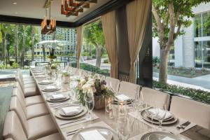 uma mesa longa com pratos brancos e flores em Avenue of the Arts Costa Mesa, a Tribute Portfolio Hotel em Costa Mesa