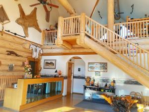 a living room with a wooden staircase in a house at Bear's Claw Lodge in Cache Creek
