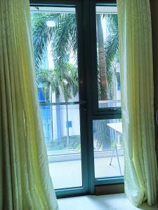 a window with a view of a palm tree at 1BR at TWO PALMTREE VILLAS Across Manila airport terminal 3 in Manila