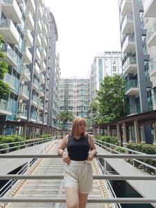 a woman standing on a bridge in a city at 1BR at TWO PALMTREE VILLAS Across Manila airport terminal 3 in Manila