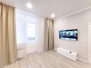 ein Wohnzimmer mit einem Flachbild-TV an der Wand in der Unterkunft Уютные апартаменты ЖК Galamat towers in Taldykolʼ