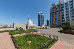 a park in the middle of a city with tall buildings at Raisson Ahotel H252 in Taldykolʼ