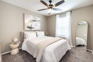 1 dormitorio con cama blanca y ventilador de techo en NEW! Beautiful and Spacious Home, en Ozark