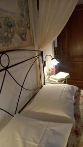 een slaapkamer met een wit bed en een tafel met een lamp bij Cottage Il Poderino in Londa