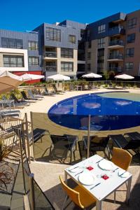 a pool with tables and chairs next to a building at Club Wyndham Lakes Entrance in Lakes Entrance