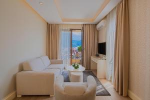 a living room with white furniture and a large window at Aparthotel Villa Aria in Budva