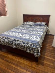 a bed with a blue and white comforter on it at Albergue Camry Backpackers佳美背包客旅馆 in Cuenca