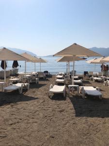 a group of lounge chairs and umbrellas on a beach at Luxury House by the Sea Marmaris in Marmaris