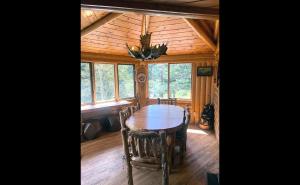 ein Esszimmer mit einem Tisch und Stühlen in einer Hütte in der Unterkunft Mountain Masterpiece by Rocky Mountain Resorts in Allenspark