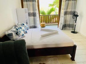 a bed in a room with a window at Waves & Wanderlust Haven in Diani Beach