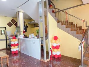 um átrio com uma escada com balões coloridos em Jun and Helen Hotel and Restaurant em Angeles