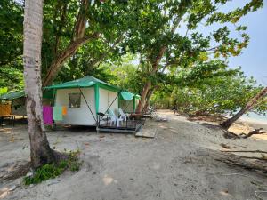 una tienda sentada en una playa junto a los árboles en Koh Ngai Camping Restaurant @ Bar en Ko Ngai