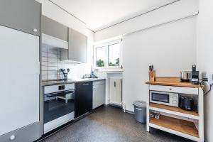 una cocina con electrodomésticos blancos y una ventana en Cooldis 9 !Gratis Parken, Free Parking!, en Kreuzlingen