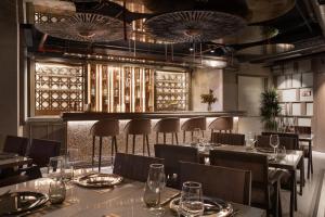 un restaurant avec des tables et des chaises et un bar dans l'établissement Burdock Hotel Istanbul, Autograph Collection, à Istanbul