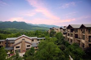 JW Marriott Hotel Zhejiang Anji في انجى: مجموعة مباني فيها جبال في الخلف