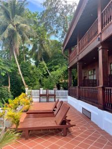 a wooden deck with a bench on a house at Namkhan Riverview Aphay in Luang Prabang