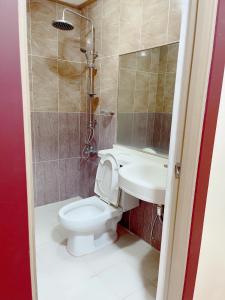 een badkamer met een toilet en een wastafel bij Jun and Helen Hotel and Restaurant in Angeles