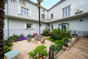 an outdoor patio with furniture and plants in front of a building at La Maison Jaffran, suite en ville in Privas