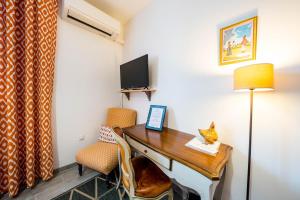 a room with a desk and a tv and a chair at La Maison Jaffran, suite en ville in Privas