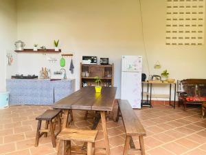 La cuisine est équipée d'une table et de chaises en bois ainsi que d'un réfrigérateur. dans l'établissement PaPa Coffee & Homestay, à Xã Tân Phát