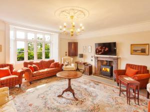 a living room with orange furniture and a fireplace at Crablake Farmhouse in Exeter
