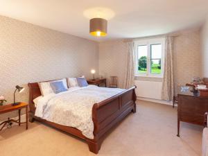 a bedroom with a large bed and a window at Crablake Farmhouse in Exeter