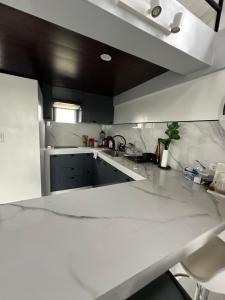 eine Küche mit weißen Arbeitsflächen und einer weißen Arbeitsplatte in der Unterkunft Rakitero holiday home in Infanta