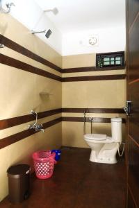 - une salle de bains pourvue de toilettes et d'une poubelle dans l'établissement Munroe Vision Panakkattu Homestay, à Munroe Island