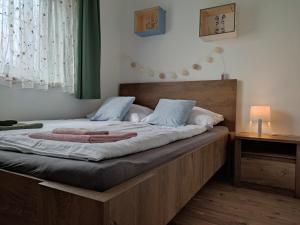 - une chambre avec un grand lit et une tête de lit en bois dans l'établissement Kenderhordó Pihenőház, à Zánka