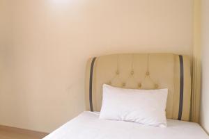 a bed with a white pillow on top of it at OYO Life 92632 Kost Pondok Kito in Jambi