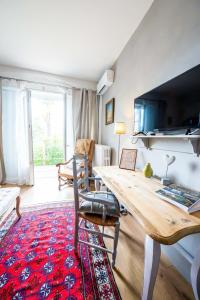 a living room with a wooden table and a large window at La Maison Jaffran, suite en ville in Privas