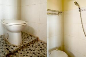 a bathroom with a toilet and a tiled floor at OYO Life 92632 Kost Pondok Kito in Jambi