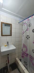 a bathroom with a sink and a shower curtain at Lynn's Getaway Hotel in Apia