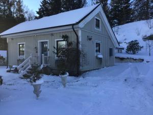 una pequeña casa en la nieve con nieve en AirbnbEkåsberg en Olofstorp