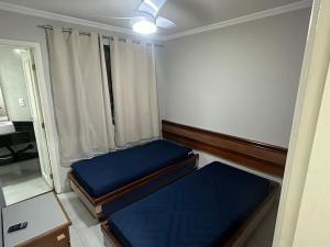 a small room with two beds and a window at BEIRA MAR 3 suítes, lavabo, 2 Vagas Garagem, varandão, Smart TV- MELHOR LOCALIZAÇÃO - WIFI Vivo Fibra in Guarapari