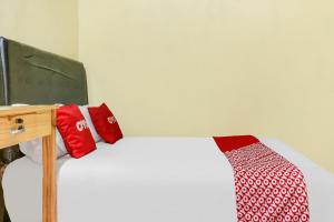a bedroom with a bed with red and white pillows at OYO Life 91335 Micheline Family 2 Syariah in Karawang