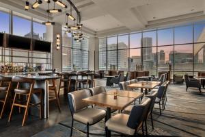 um restaurante com mesas e cadeiras e janelas grandes em Detroit Marriott at the Renaissance Center em Detroit