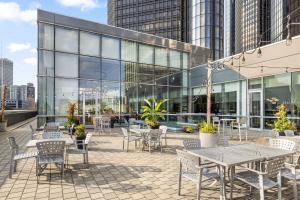 um pátio com mesas e cadeiras em frente a um edifício em Detroit Marriott at the Renaissance Center em Detroit
