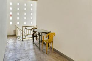 een tafel en stoelen in een kamer met een muur bij OYO Life 91205 Rindang Guesthouse Syariah in Karawang