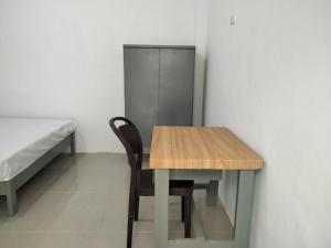 uma mesa e cadeira num quarto com uma cama em OYO Life 93054 Th Residence 135 Syariah em Medan