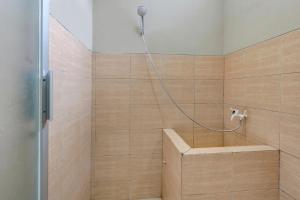 ein Bad mit einer Dusche mit einer Bank in der Unterkunft OYO Life 90159 Puri Asoka Guest House in Tuntang