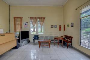 ein Wohnzimmer mit einem Tisch und Stühlen sowie einem TV in der Unterkunft OYO Life 90159 Puri Asoka Guest House in Tuntang