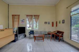 a living room with a table and chairs and a tv at OYO Life 90159 Puri Asoka Guest House in Tuntang