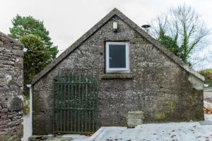 a small building with a window and a fence at The Calf House in Borrisoleigh