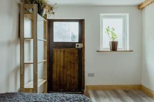 a room with a wooden door and a window at The Calf House in Borrisoleigh