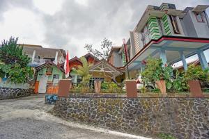 a row of houses with a stone wall at OYO Life 90321 Ken Ken Villa in Batu