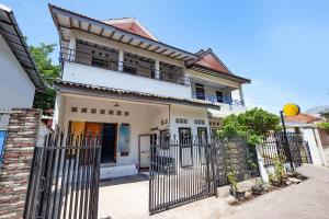 una casa bianca con una recinzione di fronte di OYO Life 1942 Asia Residence Syariah a Semarang
