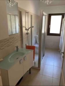 ein Bad mit einem Waschbecken und einer Dusche in der Unterkunft Film festival bedroom in Lido di Venezia