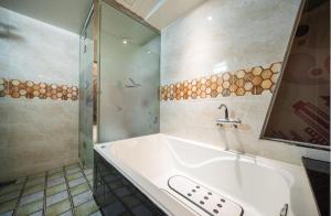 a bathroom with a tub and a shower and a sink at Hotel Kobos in Ulsan